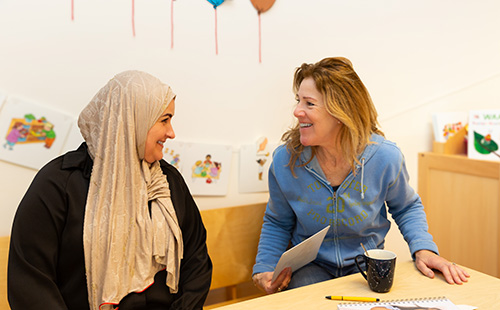 Twee pedagogisch professionals zitten aan tafel. 