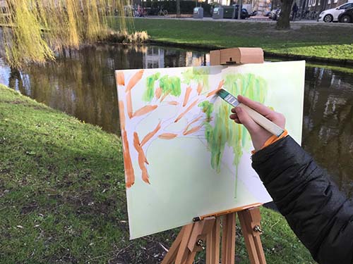 Kinderen van de BSO schilderen buiten.