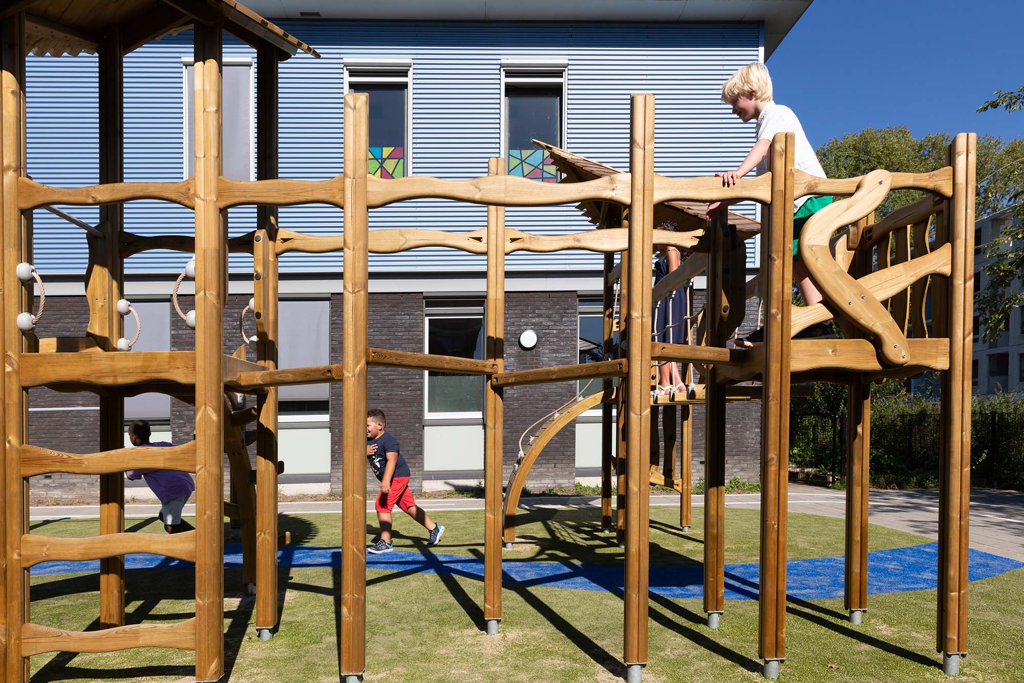 Jongens spelen buiten op een klimrek.