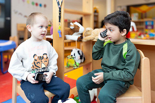 Peuters spelen met een telefoon op de peuteropvang. 