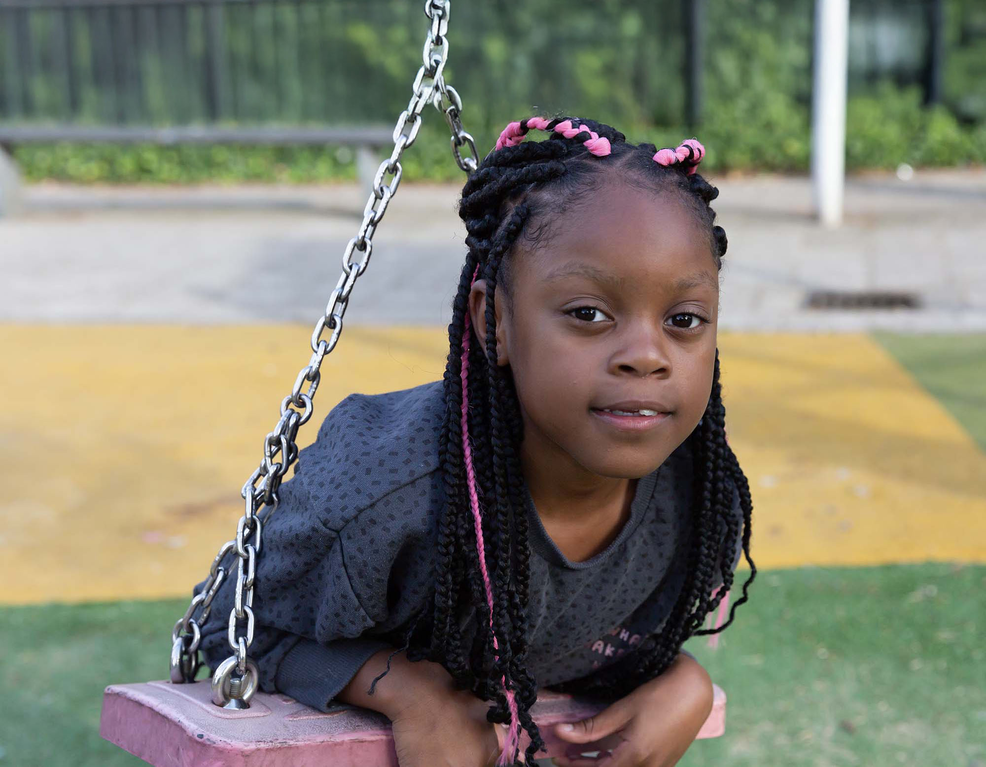 Meisje schommelt buiten bij kinderopvang locatie.