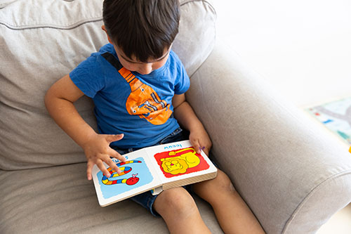 Peuter lees een boekje op de peuteropvang. 