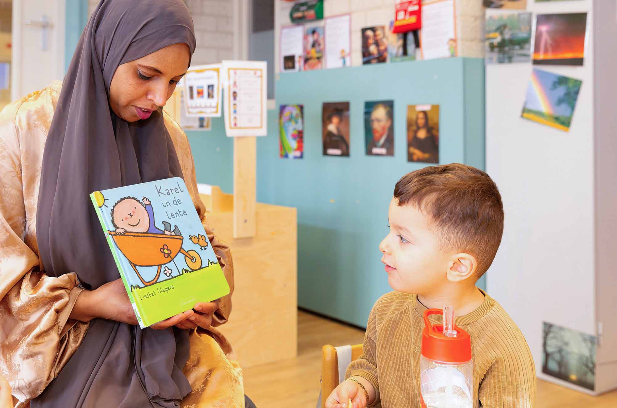 Pedagogisch professional leest peuter voor. 