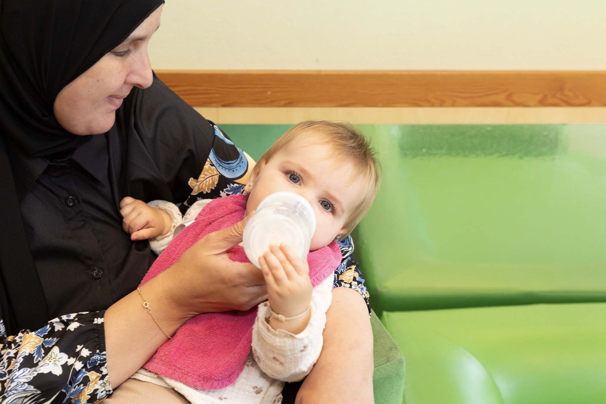 Pedagogisch professional geeft een baby de fles.