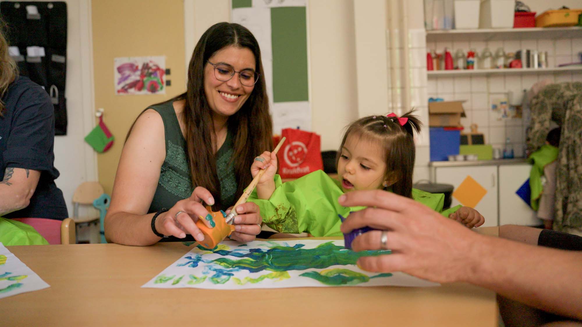 Moeder en peuter verven samen bij de samenspeelgroep.